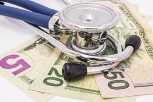 bigstock-Stethoscope-Lying-On-The-Money-290184502-web