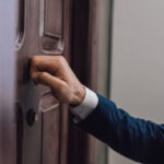 Cropped view of collector knocking on door with hand